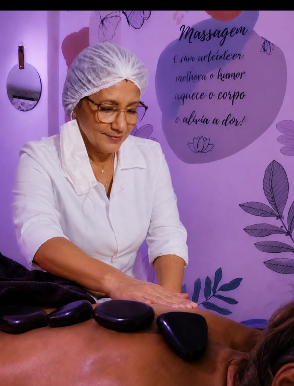 Ângela Dutra aplicando massagem com pedras quentes